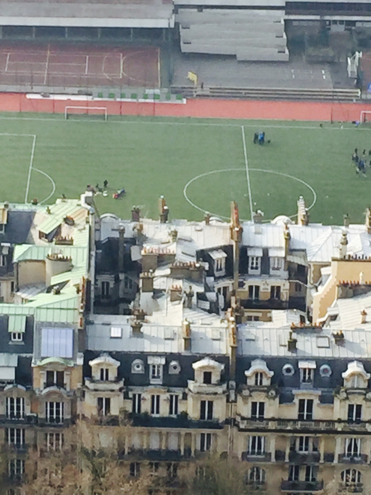 Paris rooftops and a neighborhood football pitch seen from above